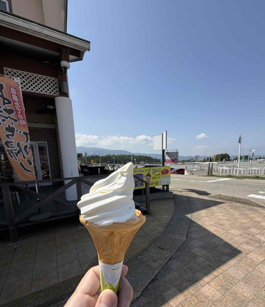 プレイアースパーク富山の豊かな自然を窓から望む、ヨッテカーレ城端のソフトクリームの写真。家族みんなで笑顔でゆったりと過ごせる空間です。